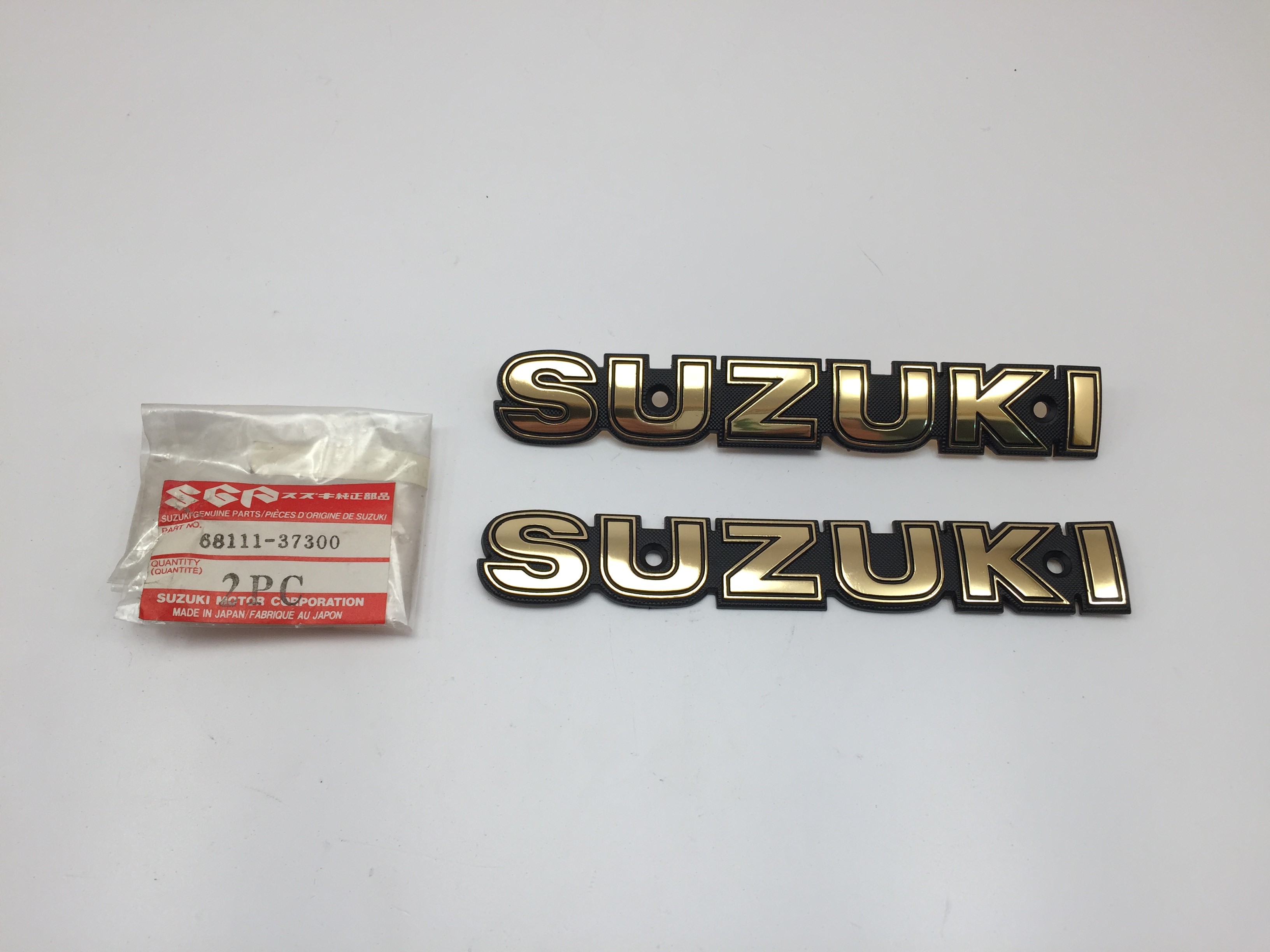 Emblème Suzuki pour GN125 et GN250 (89-00) Pièce Neuve d'origine