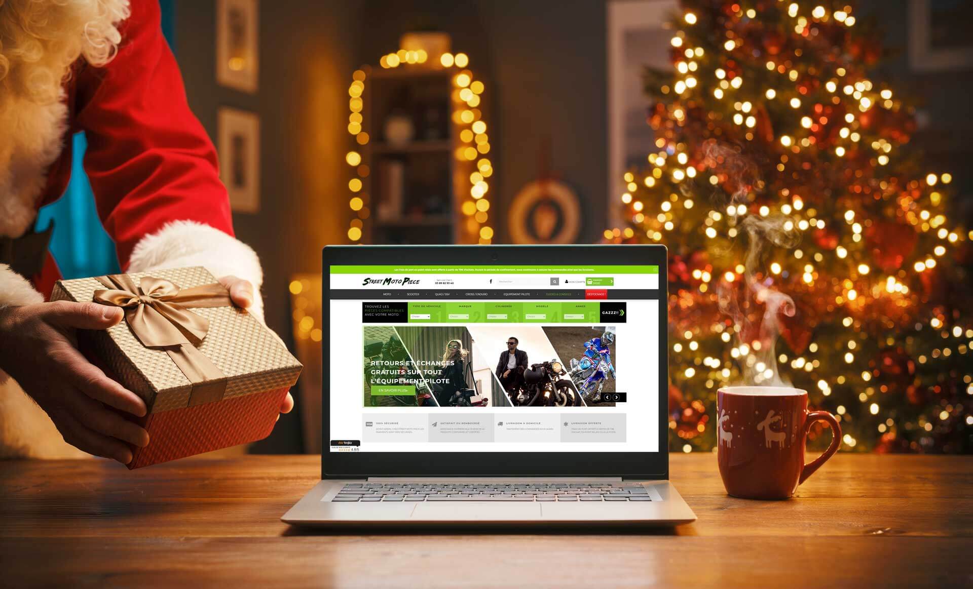 Père Noël avec un cadeau et vue sur le site e-commerce de moto Street Moto Piece